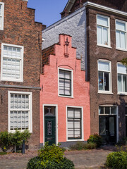 Fototapeta premium Colorful pink gabled house with historic brick neighbors in Leiden old town, Netherlands