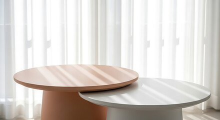 Illustration of two modern, round coffee tables, one peach and one white, placed indoors with sunlight streaming through sheer curtains