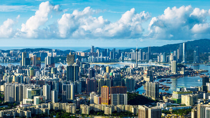 Fototapeta premium Panoramic view of the modern city skyline and commercial buildings surrounded by the sea in Macau on a sunny day.