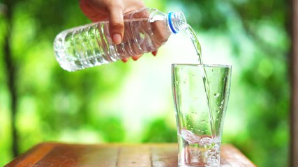 Water pouring into glass from a plastic water bottle. Natural videography. 4k - Powered by Adobe