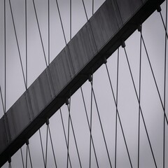 Naklejka premium Square crop of bridge cables with intersecting shadows and sharp angles