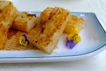 Turnip Cake on the table. Chinese Yum Cha scene. Traditional, common and popular food in Yum Cha culture. Chinese culture and Chinese cuisine. Food and beverage concept.