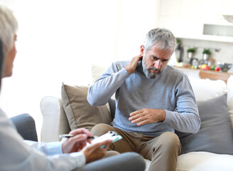 Portrait of a senior mature or mid aged man looking thoughtful or stressed and sad while sitting in...