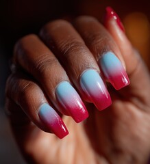 Close up of hand with long nails painted in pink and blue gradient