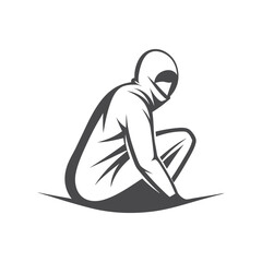 Person in full grey hooded suit crouches low on ground looking downward