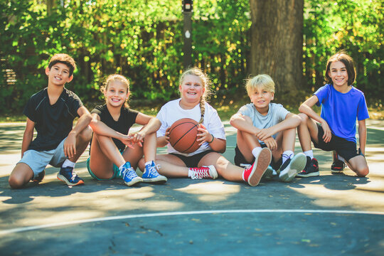 teens in sportswear playing basketball game outside together - Powered by Adobe