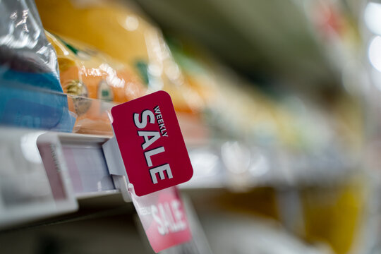 Weekly sale sign on supermarket shelf in grocery store.