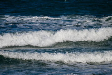 Foamy sea waves crash in layers beneath a clear sky, capturing the restless beauty of the open sea in Bulgaria