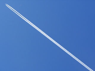 Long white jet is flying through the sky
