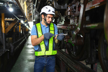 man in  green vest is working on  train