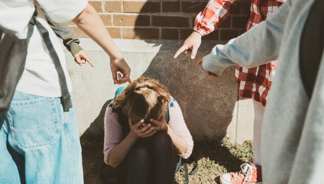 sad moment Elementary Age Bullying in Schoolyard, pointing a girl