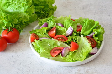 a healthy salad with tomatoes, red onion and lettuce