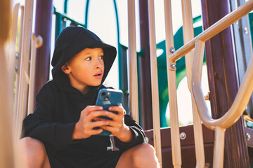 Portrait of teen using cellphone on school playground