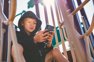 Portrait of teen using cellphone on school playground