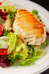 Grilled chicken breast salad chicken breast tomato, green leaf lettuce, salad mix snack vegetables snack gourmet food background on the table rusticcopy space keto and paleo diet vegan and vegan food