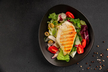 Grilled chicken breast salad chicken breast tomato, green leaf lettuce, salad mix snack vegetables snack gourmet food background on the table rusticcopy space keto and paleo diet vegan and vegan food