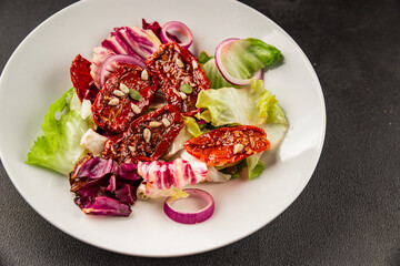 Salad sun-dried tomato green leaf lettuce, onion natural product tasty snack fresh delicious gourmet food background on the table rustic top view copy space keto and paleo diet vegan and vegan food