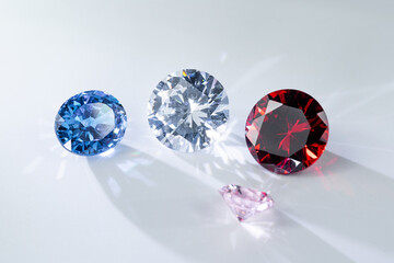 colorful gemstones including blue, clear, red, and pink round cut jewels sparkling on white background. Perfect for luxury jewelry, fashion, wealth, wedding, and elegant decoration concepts.