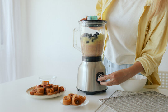 Close up of woman preparing homemade fruit leather, slicing fresh fruit in her kitchen for a healthy snack. Part of a series on organic treats and natural living. Part of a series - Powered by Adobe