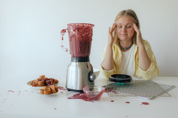 Close-up of a woman in her kitchen whose blender broke while making homemade fruit puree. The...