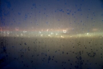 Winter sunrise over the city through a foggy window
