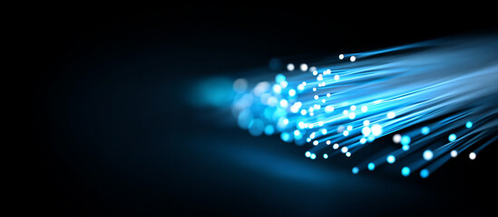 Close up of fiber optic cables emitting a vibrant blue light on black background banner - high-speed internet and modern technology.