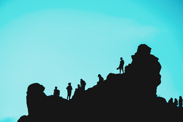 A group of people are standing on a rocky hillside