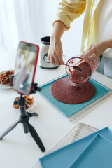Middle aged woman preparing homemade fruit leather, slicing fresh fruit in her kitchen for healthy snack. Part of a series on organic treats and natural living. User-generated content. Live streaming