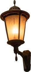 Soft glow of an old-fashioned wall lamp illuminating a cozy outdoor area at dusk