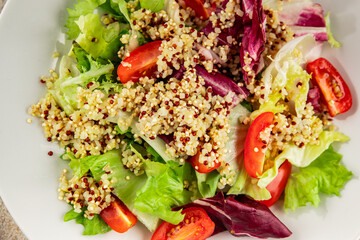 Quinoa salad tomato, green leaf salad vegetables dish natural tasty snack fresh delicious gourmet food background on the table rustic top view copy space keto and paleo diet vegan and vegan food