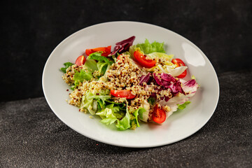 Quinoa salad tomato, green leaf salad vegetables dish natural tasty snack fresh delicious gourmet food background on the table rustic top view copy space keto and paleo diet vegan and vegan food
