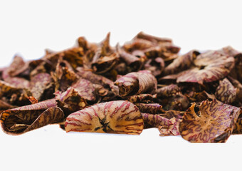 Close-up of Areca nut pieces, scattered on white background.  Detailed texture, sharp focus, India.