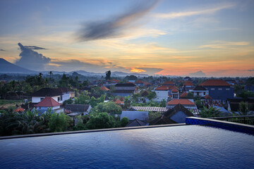 City view with a pool and a sunset in the background