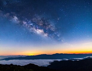 Fototapeta premium Milky Way over misty mountain range at dawn