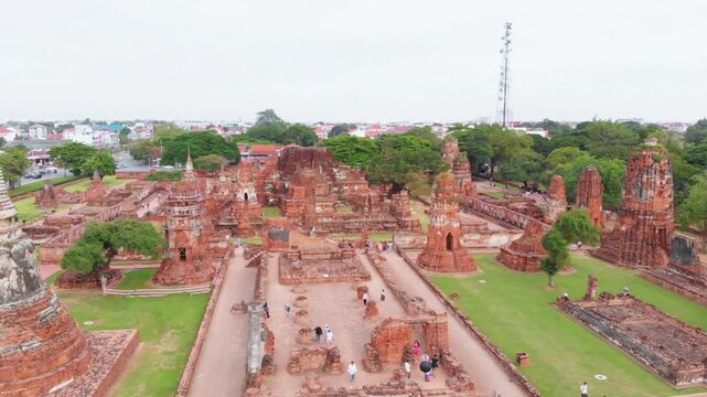 Ancient temple ruins stand majestically in ayutthaya, thailand, under a cloudy sky