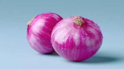Two Red Onions on Light Blue Surface in Studio Lighting