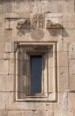 Window with stucco figures in the ancient temple of Geghard, Armenia