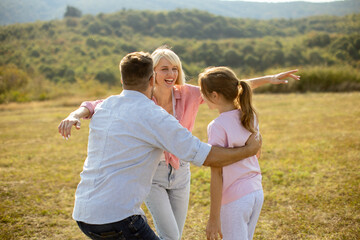Family enjoys a joyful reunion in a beautiful countryside field during sunny afternoon hours