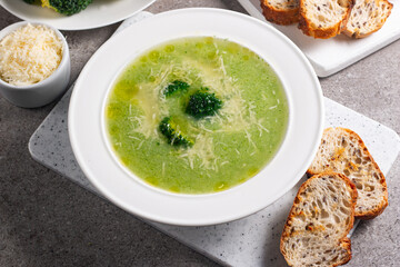 Warm and comforting creamy broccoli soup served in a bowl, garnished with parmesan cheese and croutons.