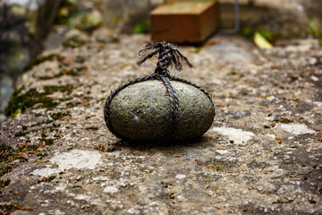 Simple round rock with traditional ropes in a park in Japan