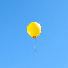 Obraz premium A single yellow balloon floating against a clear blue sky — a bold touch of minimal whimsy
