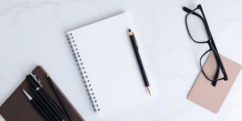Minimalist Workspace Composition Featuring Notebook, Pens, Glasses, and Neutral Color Palette
