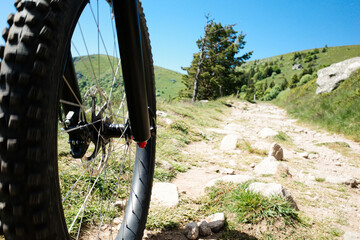 Mountainbiking in den Bergen. Reifen und Felge eines Mountainbikes auf einem holprigen Weg.