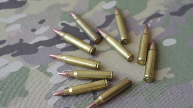 Machine gun cartridges on a camouflage background, military wallpaper. Camouflage background as a backdrop for your design
