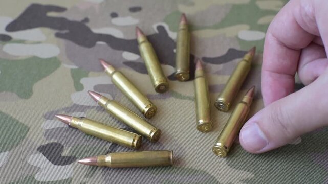 Machine gun cartridges on a camouflage background, military wallpaper. Camouflage background as a backdrop for your design