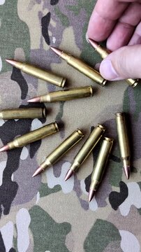 Machine gun cartridges on a camouflage background, military wallpaper. Camouflage background as a backdrop for your design