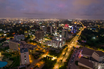 Fototapeta premium Accra, Ghana at night, aerial view of city lights and urban landscape under a twilight sky.