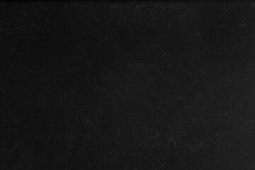 Abstract black grunge background with a scratched and distressed surface, ideal as a dark texture or overlay.