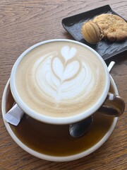 Cup of cappuccino on the table in a cafe, close up, top view