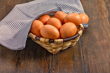 Rustic Basket of Fresh Brown Eggs on Wooden Table